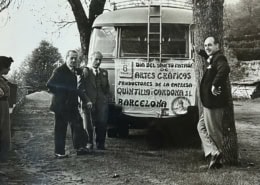 Trabajadores de la imprenta Quintilla y Cardona S.L. de Barcelona celebrando el Día del Santo Patrón de las Artes Gráficas el 6 de mayo, frente al autobús de la empresa con pancarta, años cincuenta